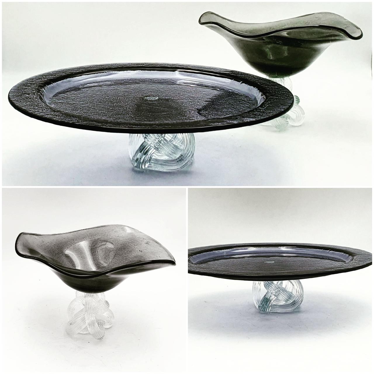 Smoked grey glass cake platter on a clear twisted foot, with a matching free-form glass bowl