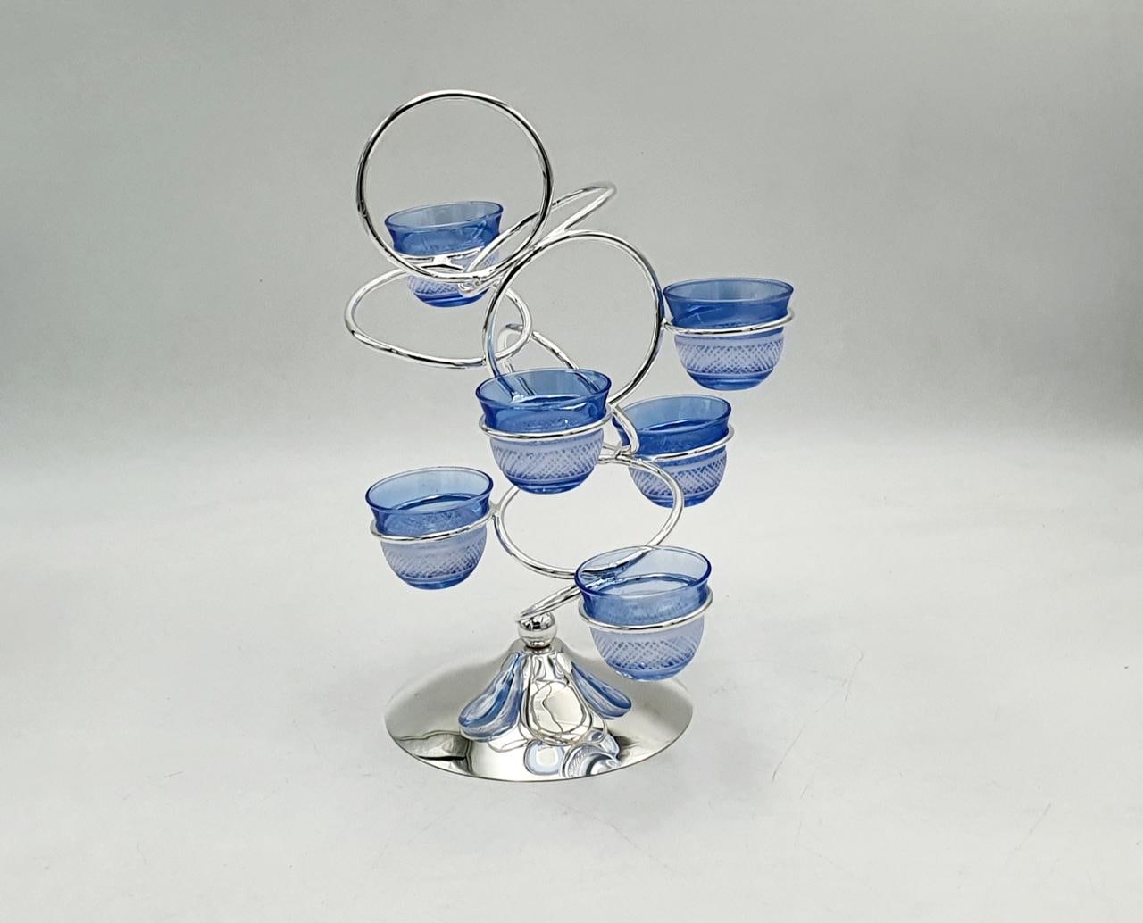 Spiral silver stand holding eight blue glass cups