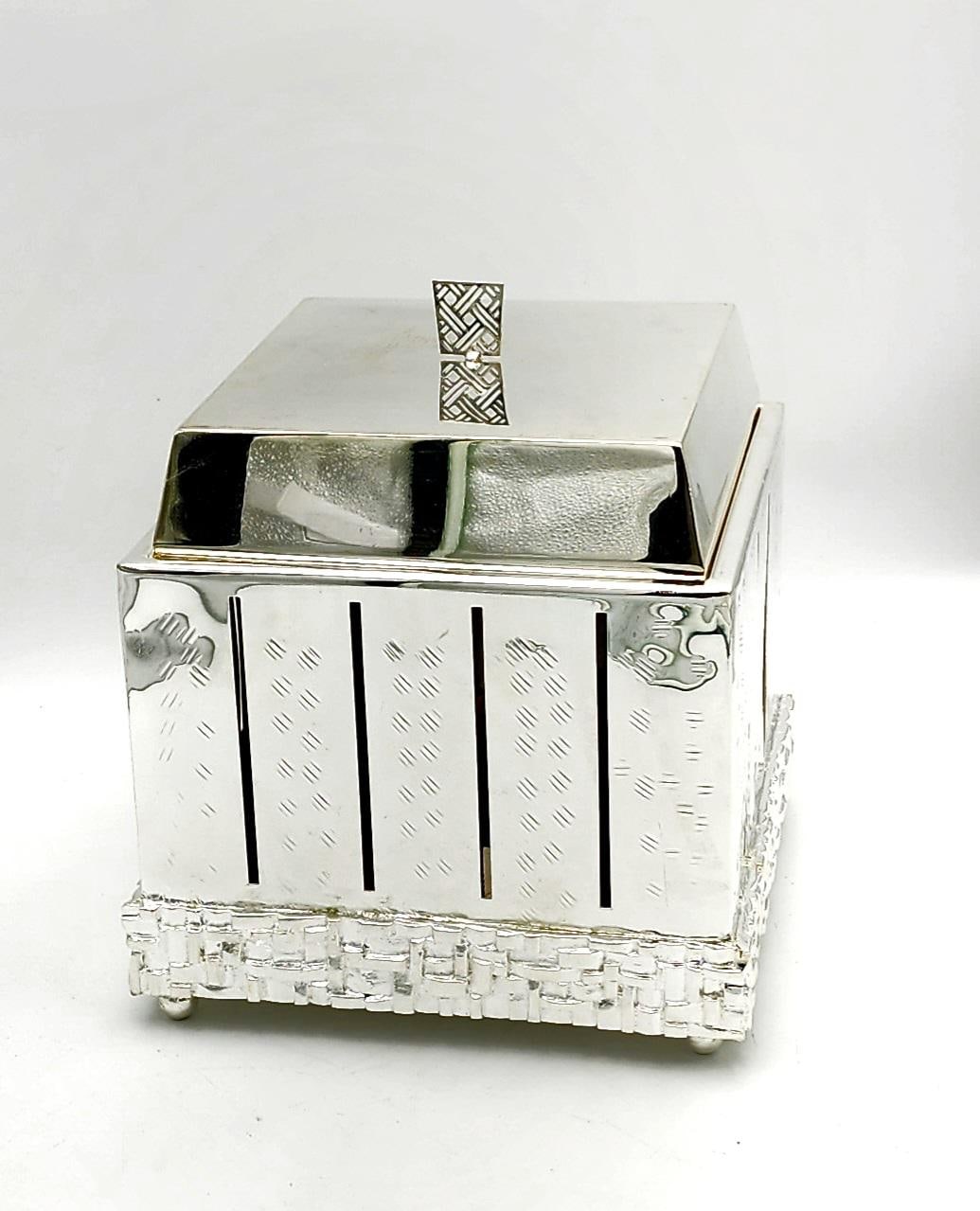 Square polished silver box with engraved panels on a crystal base